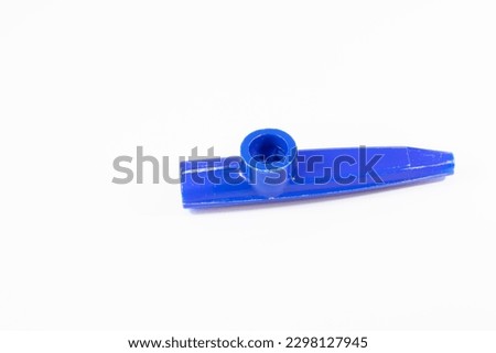 Blue kazoo, Kazoo isolated on a white background. Wind instrument idea concept. A small plastic musical instrument for children. Copy space, nobody, no people. Music education for kids.
