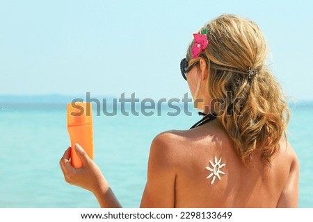 happy girl on the sea with a picture of the sun on her back
