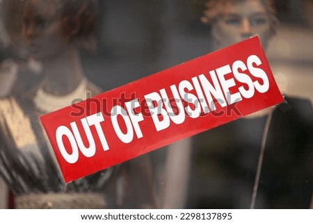 Red sign in a window shop saying "Out of business".