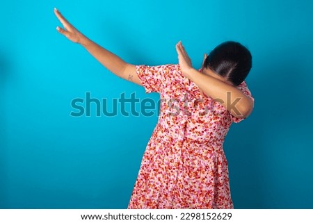 Photo of funky beautiful woman wearing floral dress over blue studio background show disco move dab