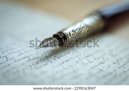 Fountain pen on an antique handwritten letter. Vintage nib pen and handwritten english  font copperplate, spencerian. Old history background. Retro style. Royalty-Free Stock Photo #2298163047