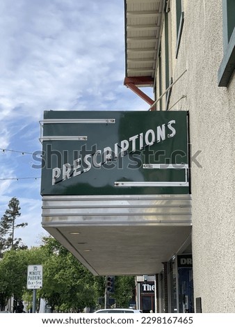 Old fashioned prescriptions sign is displayed outside a small town pharmacy