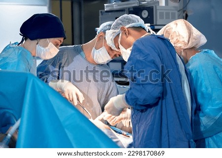 International team of surgeons in the operating room during the operation. Modern medicine, international medical workers during a complex operation