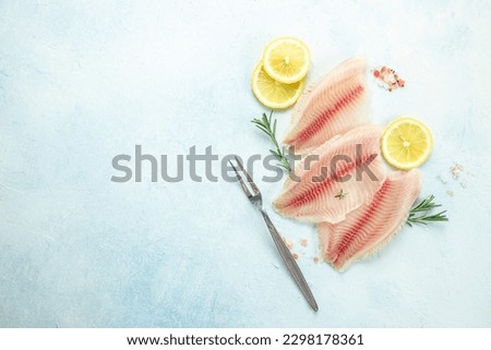 fish fillet pangasius with lemon and spices on a light background. banner, menu, recipe place for text, top view.