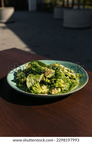 A plate of vegetable vegetarian vegetable salad of cauliflower spinach cucumber and beans on the table. Top view of green salad of Chinese cuisine in a restaurant. Delicious food for vegetarians Royalty-Free Stock Photo #2298197993