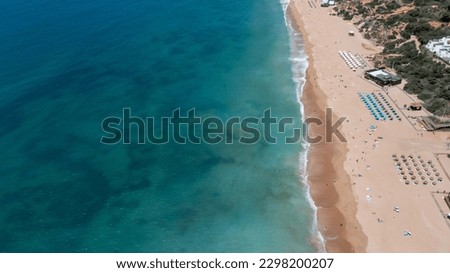 Aerial photo of the beautiful town in Albufeira in Portugal showing the Praia de Albufeira golden sandy beach, with hotels and apartments in the town, taken on a summers day in the summer time. 