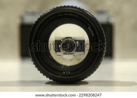 A photo looking through camera lens on a camera in the background 