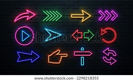 A set of neon arrows and pointers of different colors on the background of the wall.