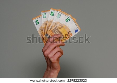 banknotes of 50 euros in a female hand on the background