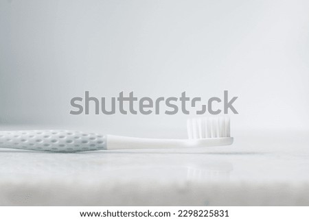 Pastel blue toothbrush with white bristles on a white background, Pastel blue toothbrush with copy space