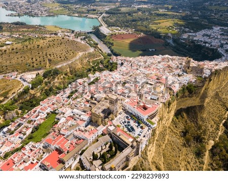 Aerial view of Arcos de la Frontera city with medieval castle on edge of cliff