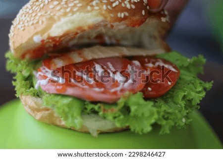 Hamburger or burger is a kind of round bread that is sliced in half, and in the middle is filled with a patty which is usually taken from meat, then vegetables such as lettuce, tomatoes and onions.