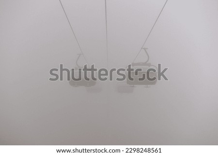 Amusement park rides, excursion with ski lift in the fog. Natural park background, abstract scenic landscape in mountains. Vacation trip ideas Royalty-Free Stock Photo #2298248561