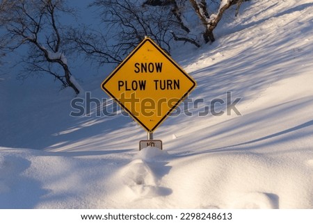 Close up picture of snow plow turn sign buried in snow