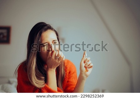 
Woman Covering Nose Spraying Perfume Indoors at Home. Motel guest trying to refresh the smell stinking up the room
 Royalty-Free Stock Photo #2298252369