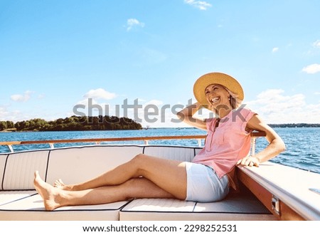 Time to get away. a mature woman enjoying a relaxing boat ride. Royalty-Free Stock Photo #2298252531