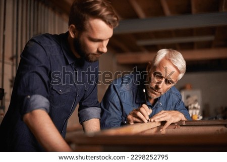 Artisans at work. a father showing his son the tricks of the building trade. Royalty-Free Stock Photo #2298252795