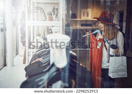 I need this color. a young woman shopping at a clothing store. Royalty-Free Stock Photo #2298252913