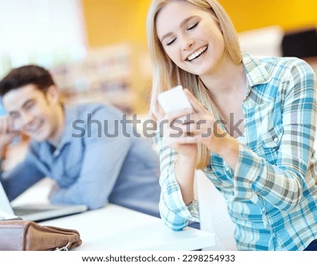 Her friend texts such funny things. Attractive female student reading a funny text with her study buddy in the background.