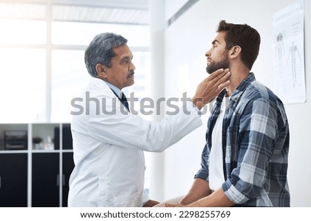 Look up for me. a mature male doctor doing a check up on a young patient whos seated on a doctors bed. Royalty-Free Stock Photo #2298255769