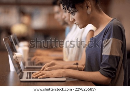 Study group dynamics. a studious young woman working on her laptop with blurred people in the background. Royalty-Free Stock Photo #2298255839