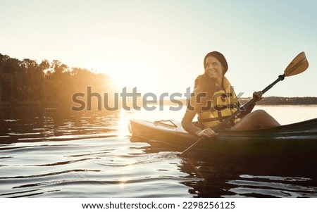 Happiness begins when you start kayaking. a beautiful young woman kayaking on a lake outdoors. Royalty-Free Stock Photo #2298256125