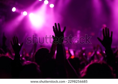 Feel the vibe. Rear view shot of a crowd enjoying a live concert with their hands raised. Royalty-Free Stock Photo #2298256685