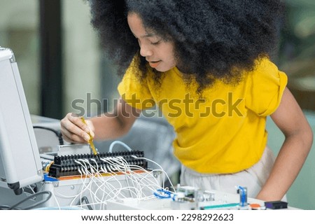 Girl female teen children concentrate enjoy Machine Learning Robot is Moving Under Control robot coding at technology stem class, stem education robot for digital automation artificial intelligence ai Royalty-Free Stock Photo #2298292623