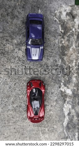Photo of two toy cars in blue and red