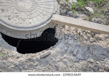 The hatch on the ground is open, the hole in the ground