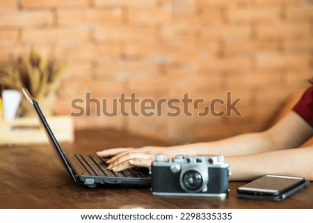 Close up hand of business woman and business friend investment consultant analyzing studying company annual financial report balance sheet statement working withlaptop mobile phone retro camera