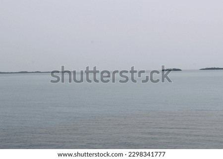 tropical island in the distance in a clear blue sea 