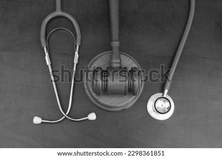 Top view of wooden gavel with stethoscope on table. Malpractice and medical mistake concept. Royalty-Free Stock Photo #2298361851