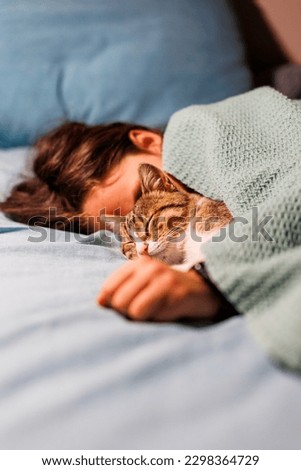 boy falls asleep and hugs his cat, who sleeps with him under the covers. children and pets. the cat sleeps with the baby. the child is getting ready for bed. Royalty-Free Stock Photo #2298364729