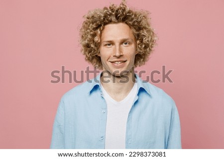 Young satisfied smiling happy attractive cheerful fun caucasian blond man wear blue shirt white t-shirt looking camera isolated on plain pastel light pink background studio portrait. Lifestyle concept