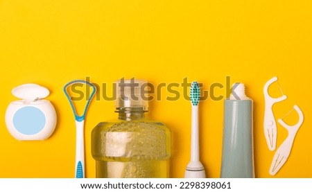 Sonic electric toothbrush, toothpaste, mouthwash, dental floss and tongue cleaner on yellow background. Oral hygiene. Dental care.Dentistry concept.Place for text.Place for copy.