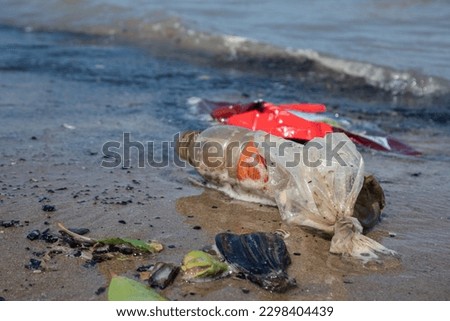 selectively focus on the waste of plastic bottles used for drinks that are thrown away on the beach. concept photo of environmental pollution and Ecological problem