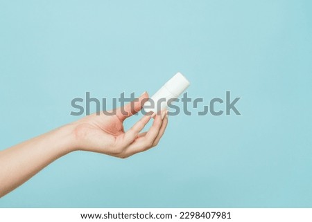 A bottle of nasal spray or eye drops in a female hand. Copy space Royalty-Free Stock Photo #2298407981