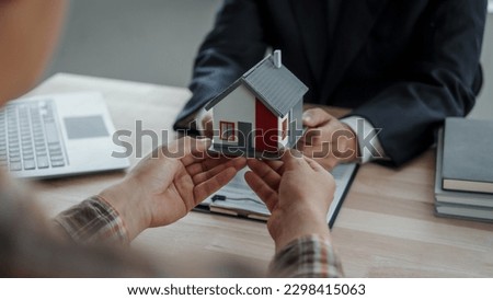 Real estate agent with client considering buying a new home To pay a bribe to sign to approve the purchase, bribery concept.