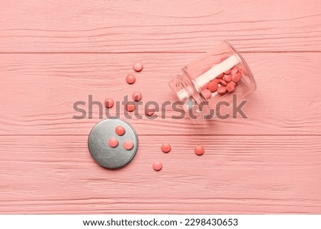 Bottle with hormonal pills on pink wooden background Royalty-Free Stock Photo #2298430653