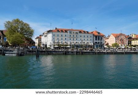 the sunlit harbor of Lindau Island on lake Constance (lake Bodensee) and historical Hotel Bayerischer Hof in the background (Lindau, Germany, May 21,2016)                                 Royalty-Free Stock Photo #2298446465