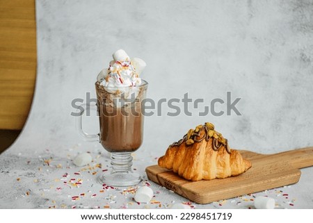 Hot Chocolate with Marshmallow and Tasty Nutella Croissant on wooden plate