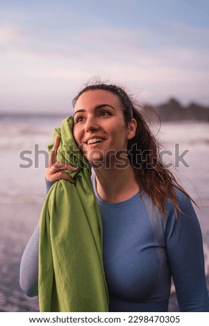 woman wiping her sweat after training on the beach.