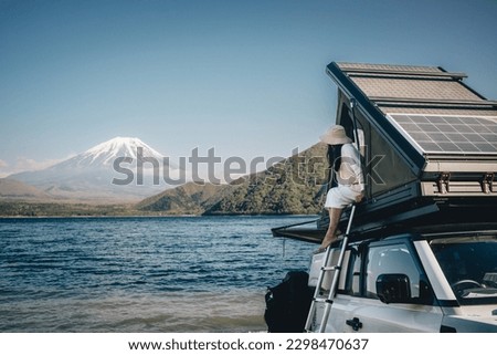 White 4x4 overland car with rooftop tent and awning at the beach and a lake with a view of Mountain Fuji, Japan.  Royalty-Free Stock Photo #2298470637