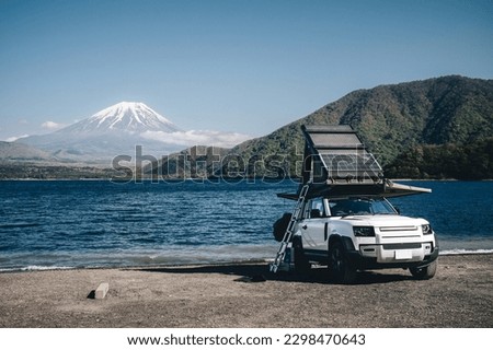 White 4x4 overland car with rooftop tent and awning at the beach and a lake with a view of Mountain Fuji, Japan.  Royalty-Free Stock Photo #2298470643