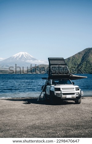 White 4x4 overland car with rooftop tent and awning at the beach and a lake with a view of Mountain Fuji, Japan.  Royalty-Free Stock Photo #2298470647