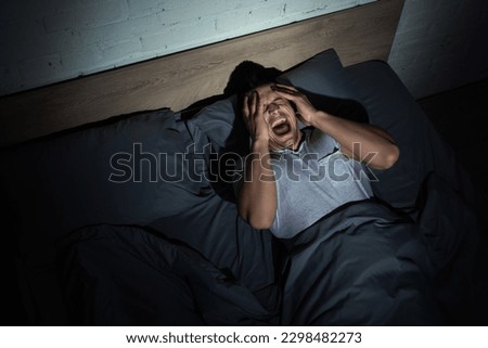 top view of young man screaming while having nightmares and panic attacks at night Royalty-Free Stock Photo #2298482273