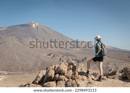 Tourist girl next to Peak of Mount Teide called 'Pico del Teide'. View of the caldera and volcanic landscape. Teide National Park, Tenerife, Canary islands, Spain.