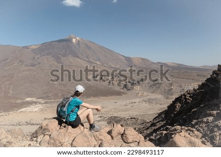 Tourist girl next to Peak of Mount Teide called 'Pico del Teide'. View of the caldera and volcanic landscape. Teide National Park, Tenerife, Canary islands, Spain.