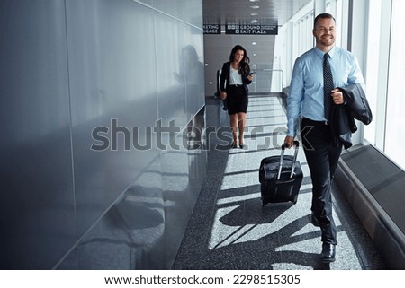 Getting out of the office for a change. two executive businesspeople walking through an airport during a business trip. Royalty-Free Stock Photo #2298515305
